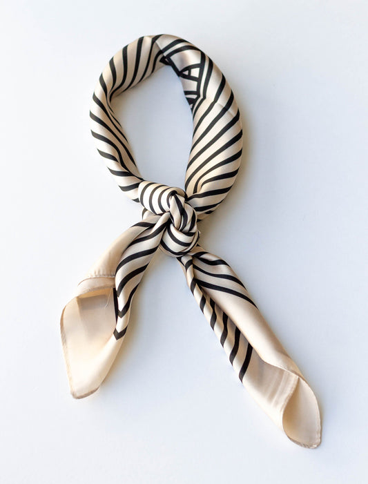 A beige scarf with black stripes, tied in a knot.