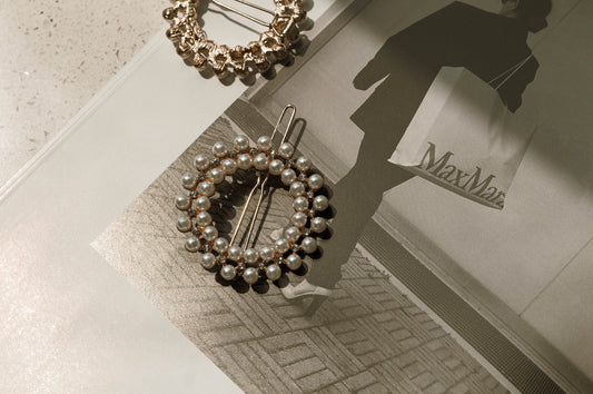 The pearl circle hairpin with rhinestone details is placed on a fashion magazine.