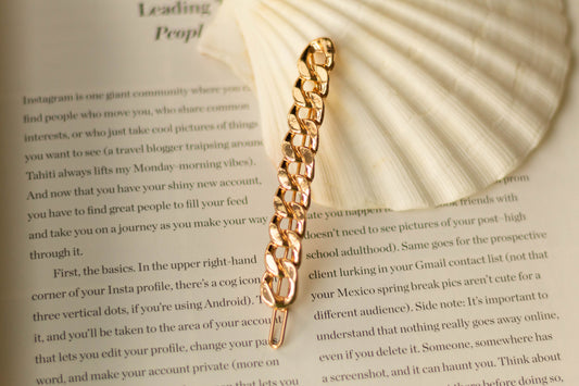 Front view of the long gold chain hairpin showing the chain detail on a seashell.